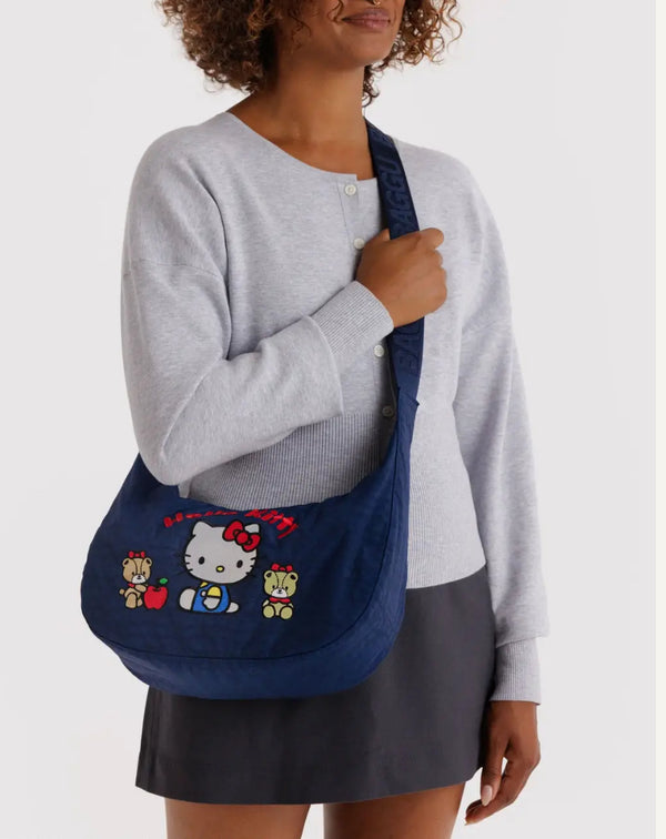 Person holding a blue bag with Hello Kitty design against a white background