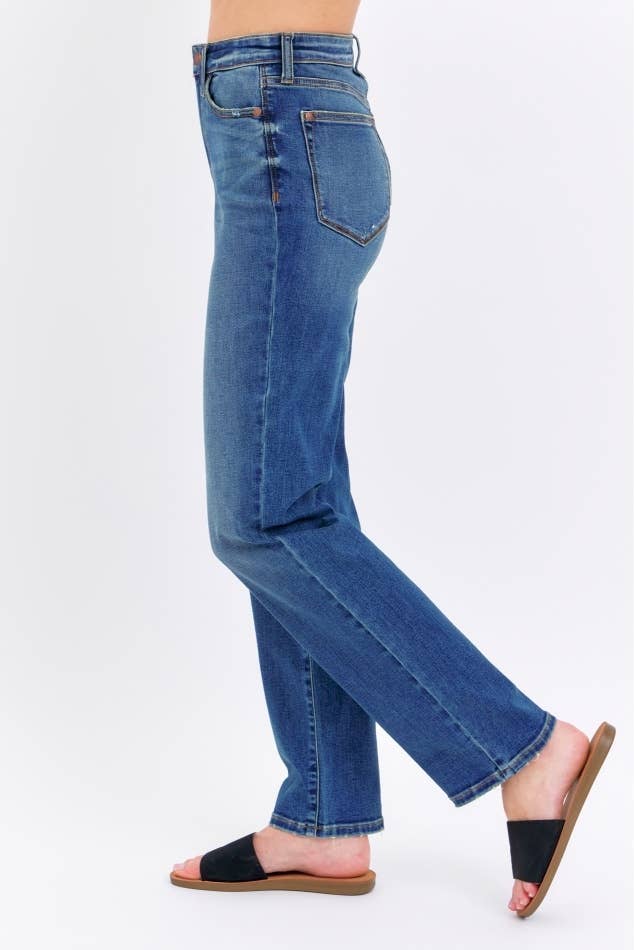 Blue jeans worn by a person on a white background