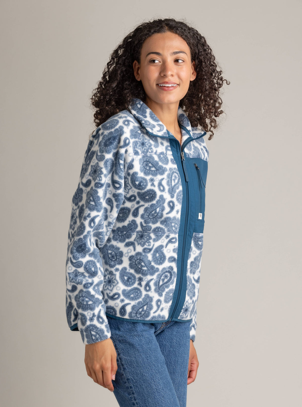 Woman wearing a blue and white patterned hoodie against a plain background