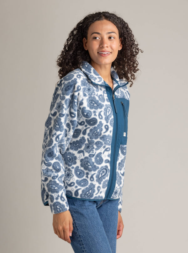 Woman wearing a blue and white patterned hoodie against a plain background