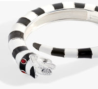Silver ring with black and white striped design and red gemstone on a white background