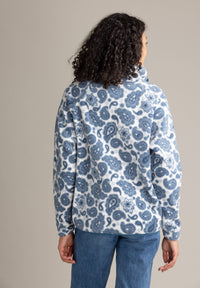 Person wearing a blue and white patterned jacket on a beige background
